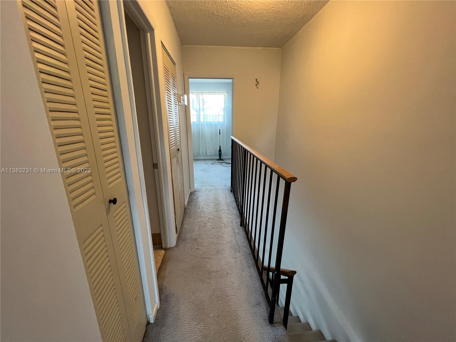 15103 Southwest 81st Street, Unit 213 Miami, FL 33193 - Photo 17 of 22 a view of a hallway with wooden floor and staircase
