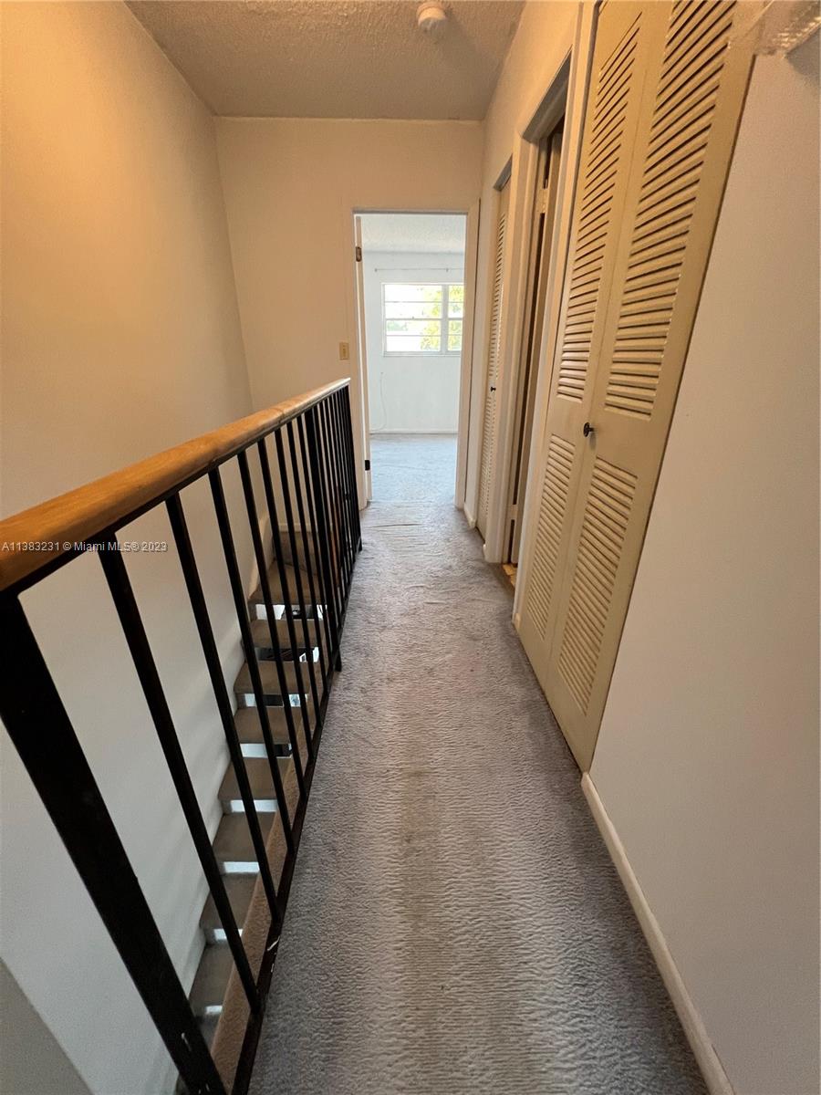 15103 Southwest 81st Street, Unit 213 Miami, FL 33193 - Photo 18 of 22 a view of a hallway with staircase