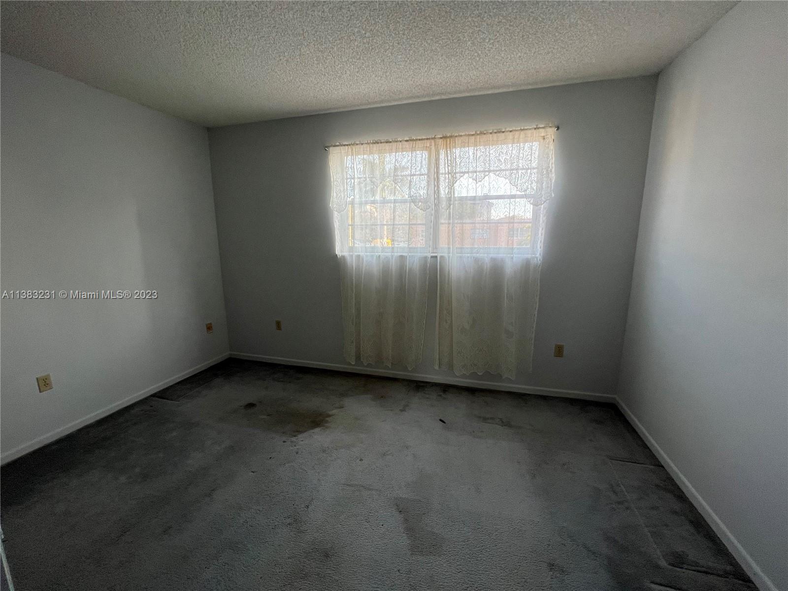15103 Southwest 81st Street, Unit 213 Miami, FL 33193 - Photo 20 of 22 an empty room with a window