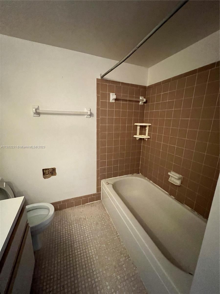 15103 Southwest 81st Street, Unit 213 Miami, FL 33193 - Photo 21 of 22 a bathroom with a sink a toilet a shower and a mirror