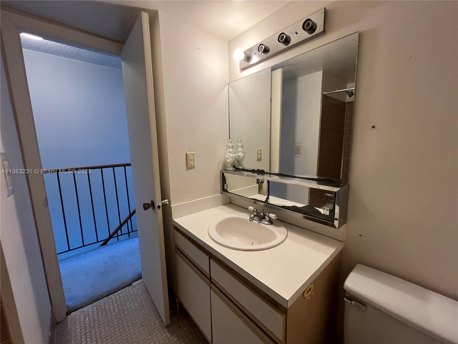 15103 Southwest 81st Street, Unit 213 Miami, FL 33193 - Photo 22 of 22 a bathroom with a sink vanity granite and a mirror