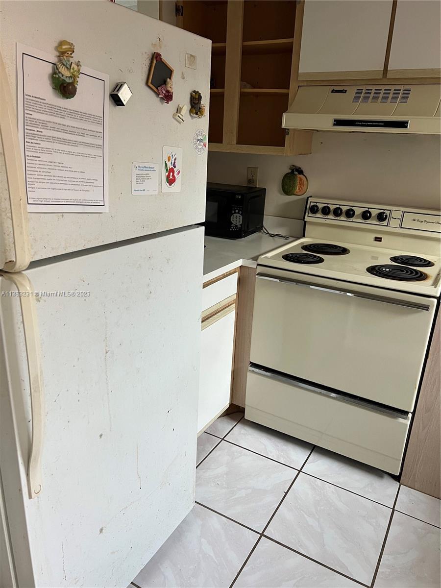 15103 Southwest 81st Street, Unit 213 Miami, FL 33193 - Photo 6 of 22 a white refrigerator freezer sitting inside of a kitchen