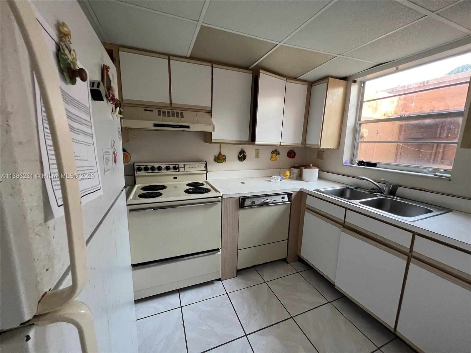 15103 Southwest 81st Street, Unit 213 Miami, FL 33193 - Photo 8 of 22 a kitchen with a stove a sink and a refrigerator