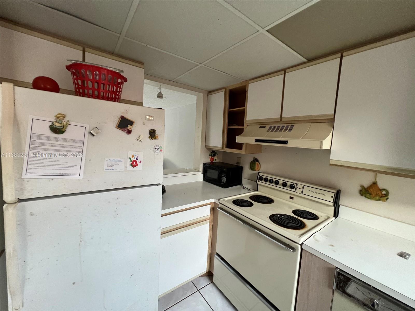 15103 Southwest 81st Street, Unit 213 Miami, FL 33193 - Photo 9 of 22 a white kitchen with a refrigerator and a stove top oven