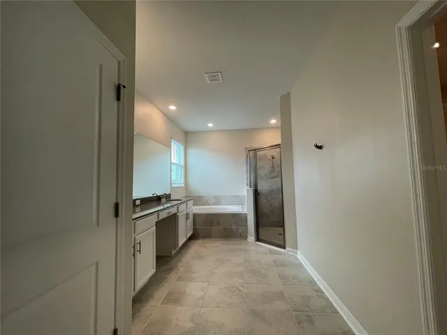 a large white kitchen with a sink and refrigerator