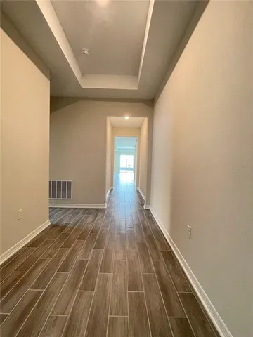 a view of empty room with wooden floor
