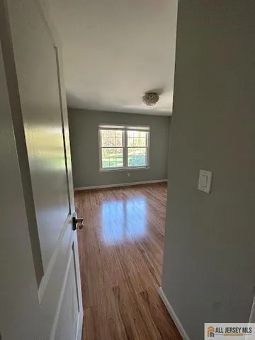 an empty room with wooden floor and entrance