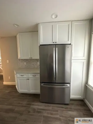 a metallic refrigerator freezer sitting in a kitchen