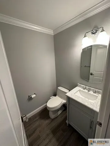 a bathroom with a granite countertop sink toilet and mirror