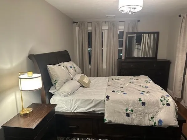 a bed sitting in a bedroom next to a window