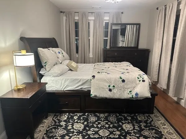 a large bed sitting in a bedroom next to a window