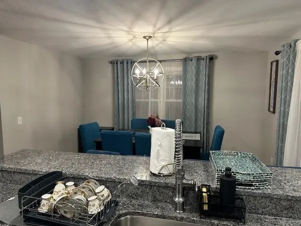 a kitchen with a stove and a dining table with wooden floor