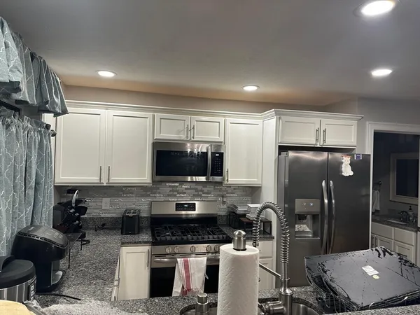 a bathroom with a granite countertop toilet sink and mirror