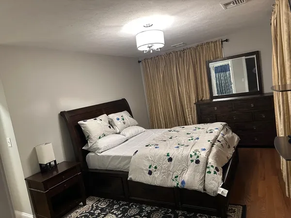 a bedroom with a large bed and a chandelier