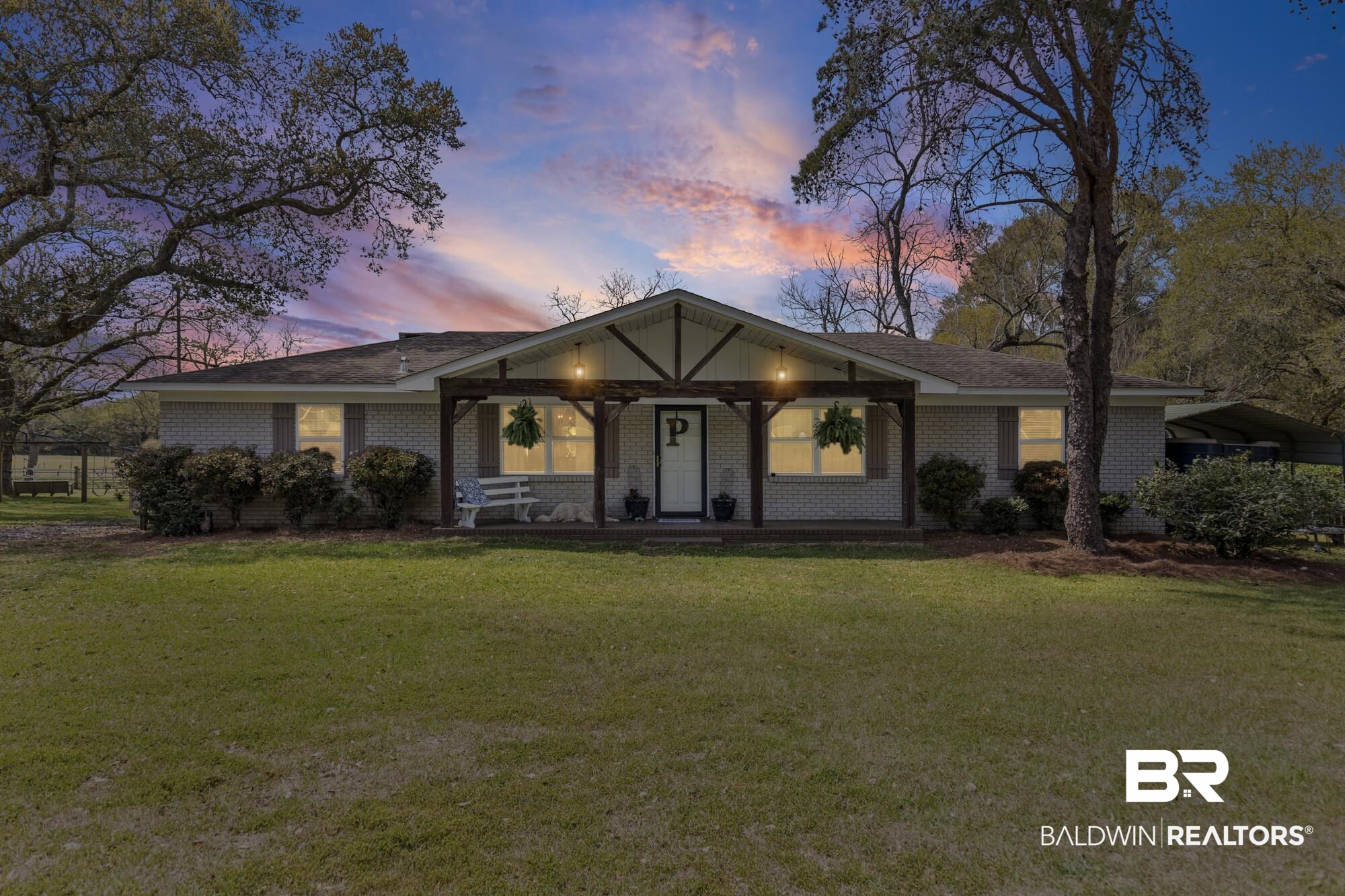 View of front of property with brick siding, a front lawn, and a porch