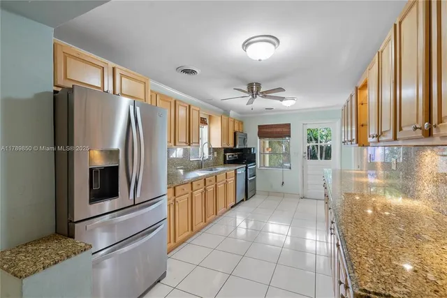a kitchen with stainless steel appliances granite countertop a refrigerator and a stove