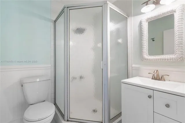 a bathroom with a toilet shower vanity and a sink