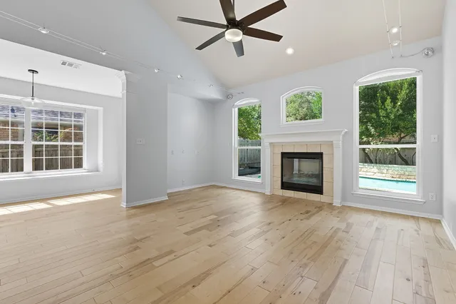 a view of an empty room with a window and fireplace