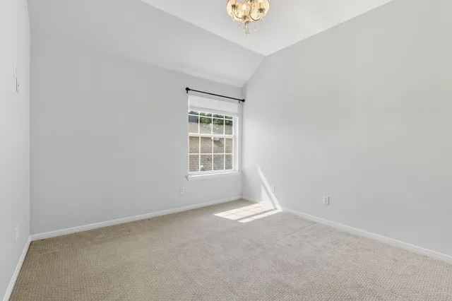 an empty room with a window and a ceiling fan