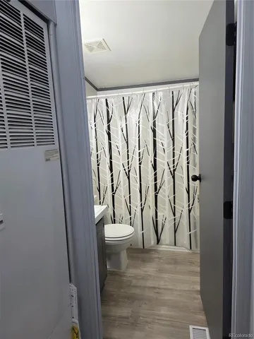 a bathroom with a toilet and a shower curtain