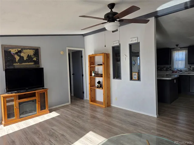 a view of a livingroom with an empty space and a kitchen space with wooden floor
