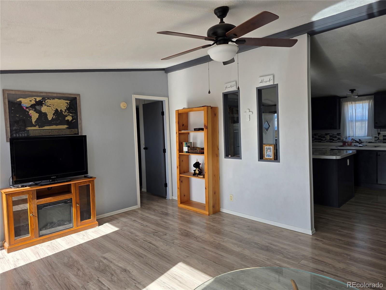 7881 Foothill Boulevard Alamosa, CO 81101 - Photo 4 of 25 a view of a livingroom with an empty space and a kitchen space with wooden floor