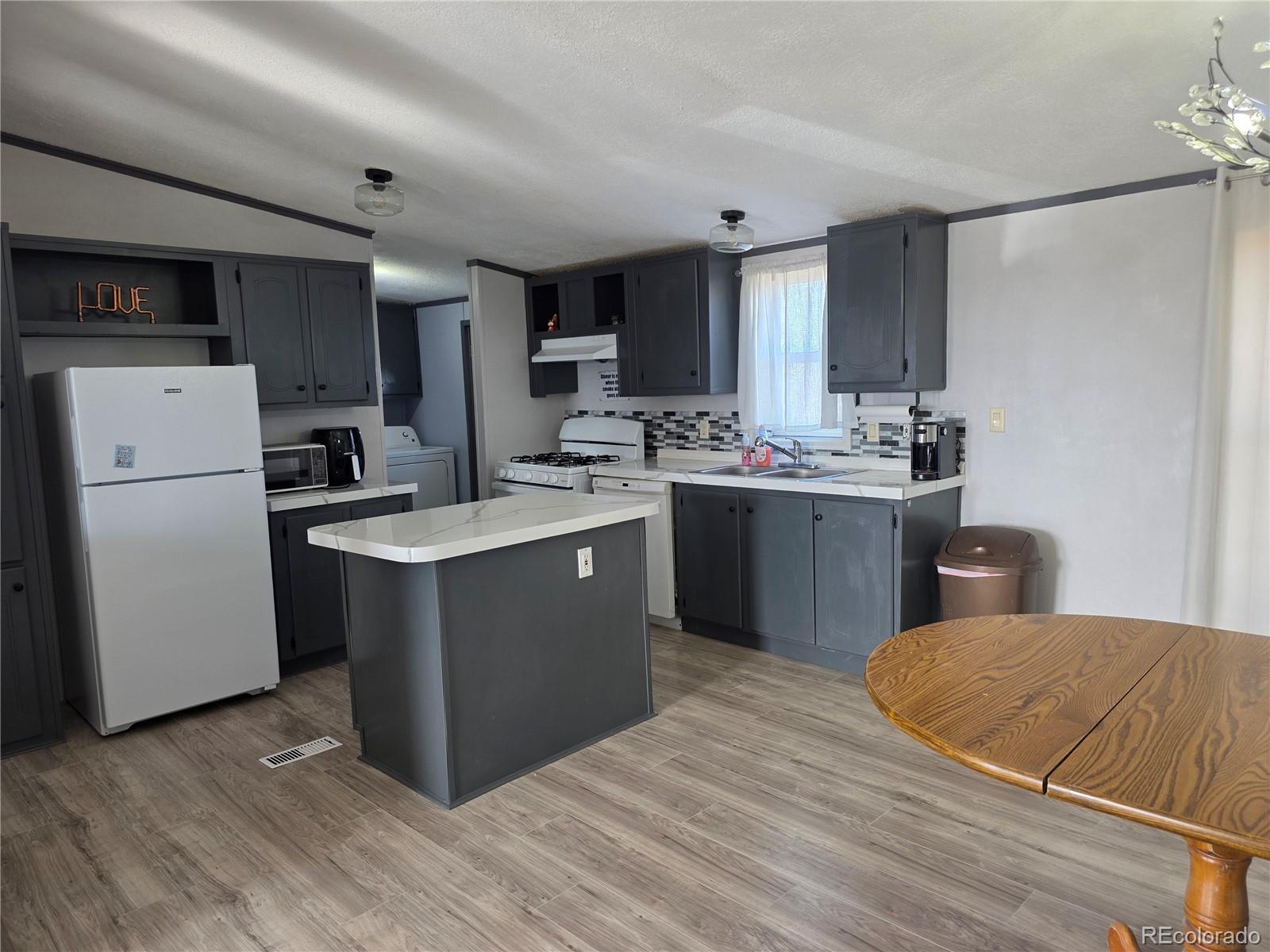 7881 Foothill Boulevard Alamosa, CO 81101 - Photo 5 of 25 a kitchen with a sink appliances and cabinets