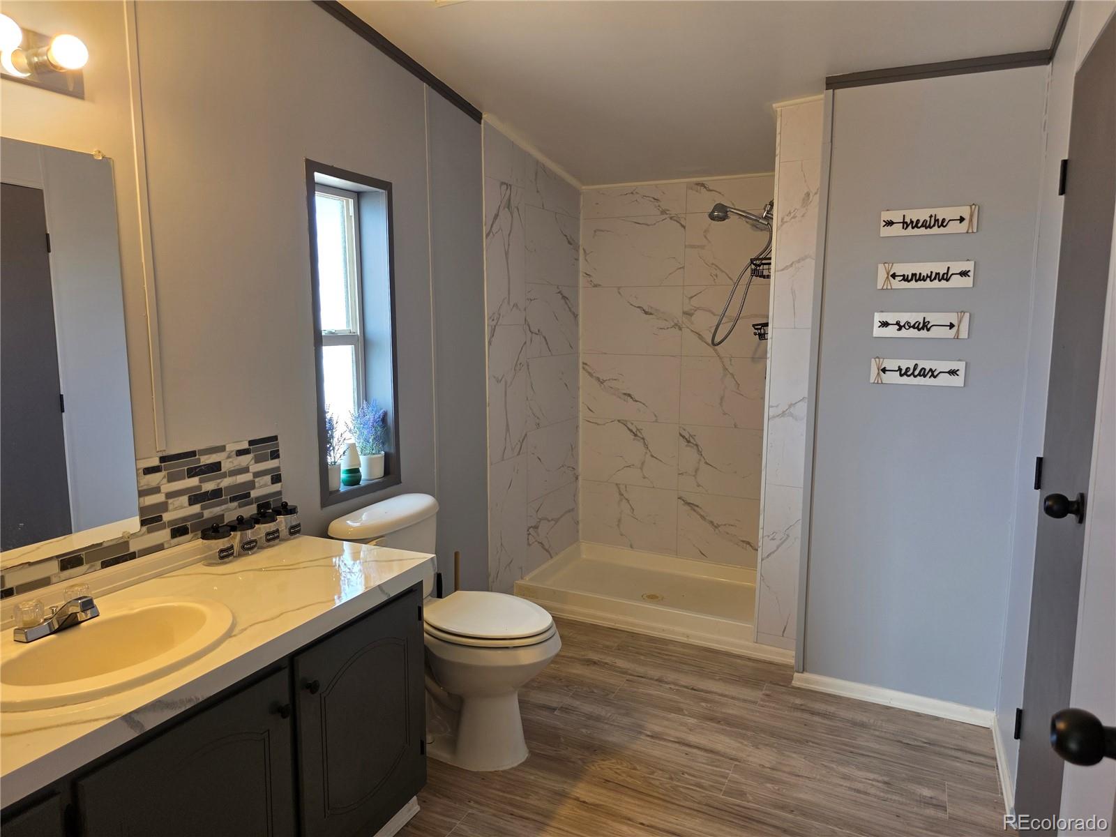 7881 Foothill Boulevard Alamosa, CO 81101 - Photo 9 of 25 a bathroom with a sink a toilet and shower