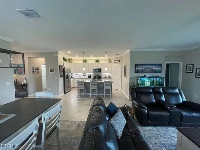 a view of a dining room and livingroom with furniture wooden floor a chandelier
