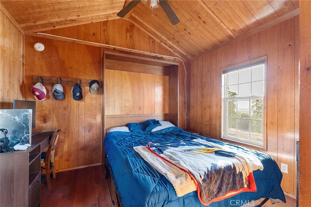 1477 Flag Creek Road Oroville, CA 95965 - Photo 42 of 75 a bedroom with a bed and wooden floor