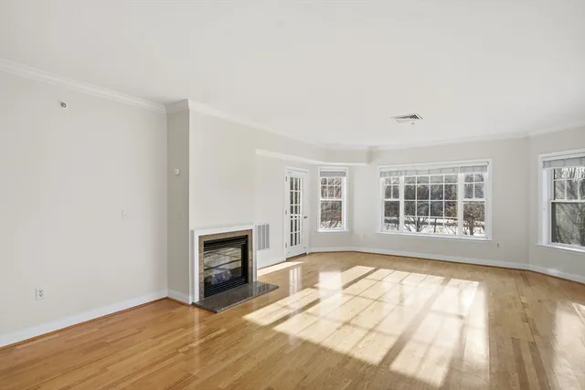 a view of empty room with a fireplace and wooden floor