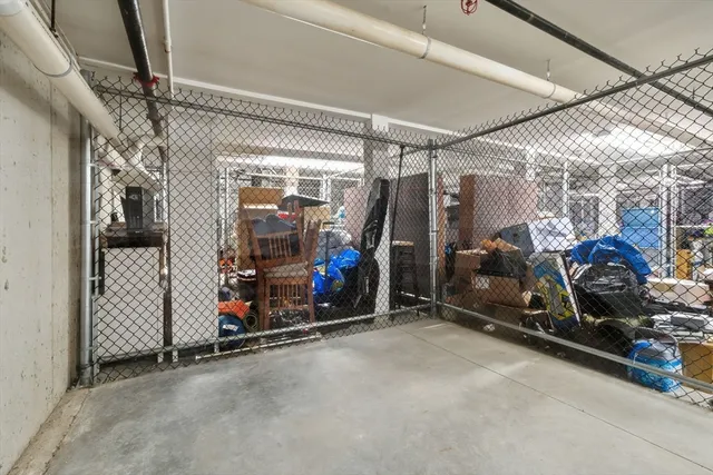 a large living room with stainless steel appliances lots of white furniture