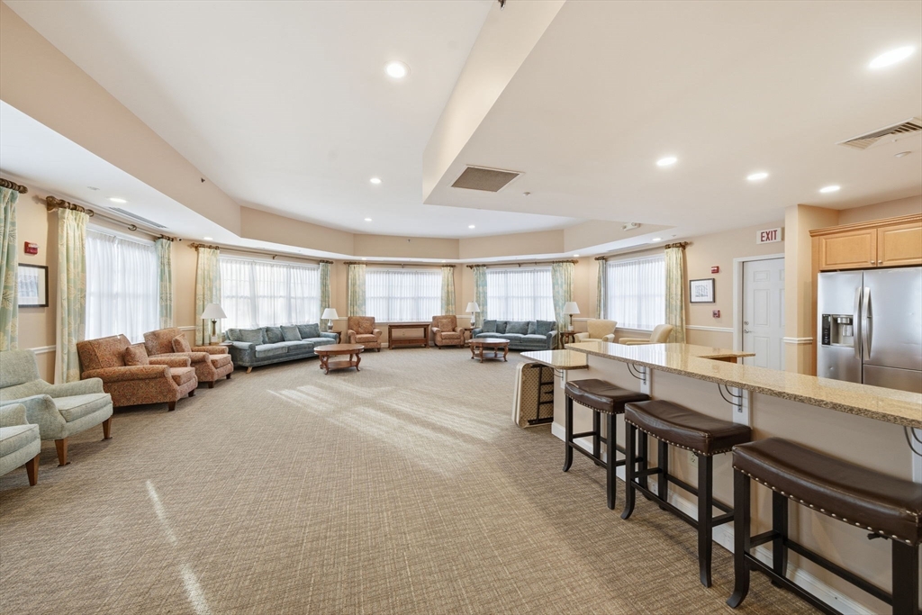 295 Salem Street, Unit 82 Woburn, MA 01801 - Photo 28 of 36 a large living room with stainless steel appliances lots of white furniture