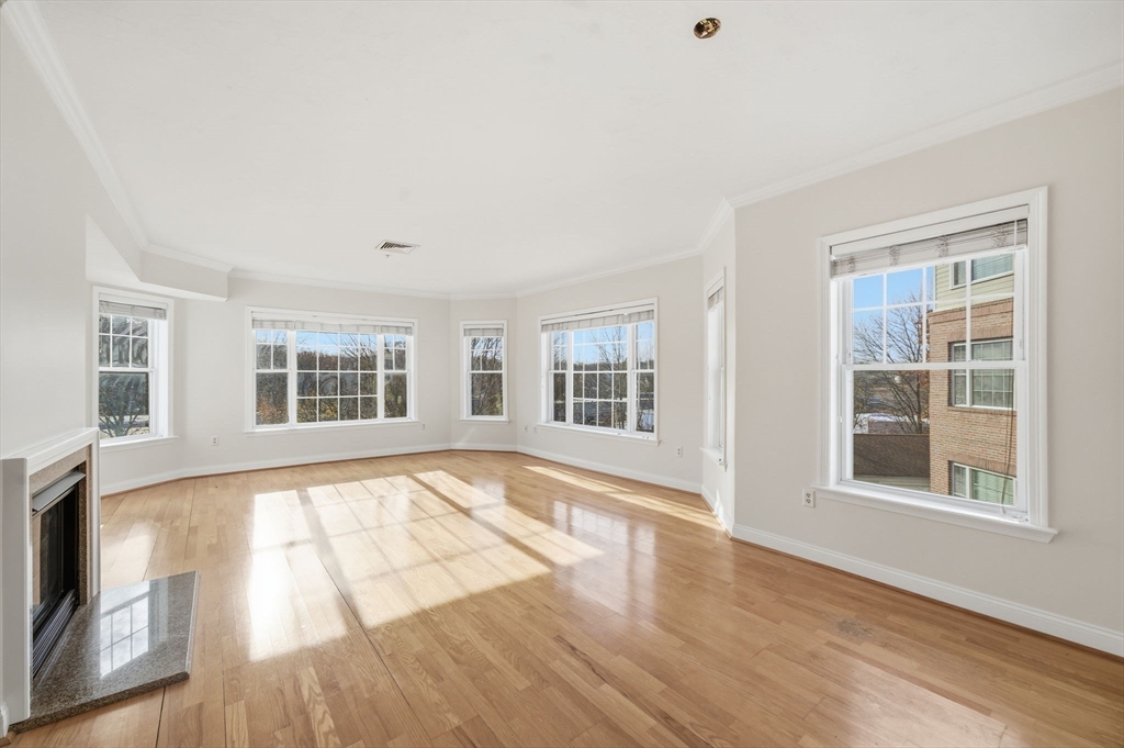 295 Salem Street, Unit 82 Woburn, MA 01801 - Photo 5 of 36 a view of an empty room with wooden floor and a window
