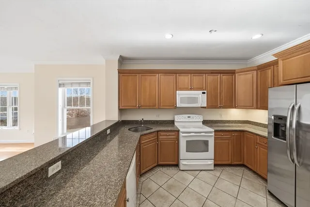 a kitchen with stainless steel appliances granite countertop a stove a sink and a refrigerator