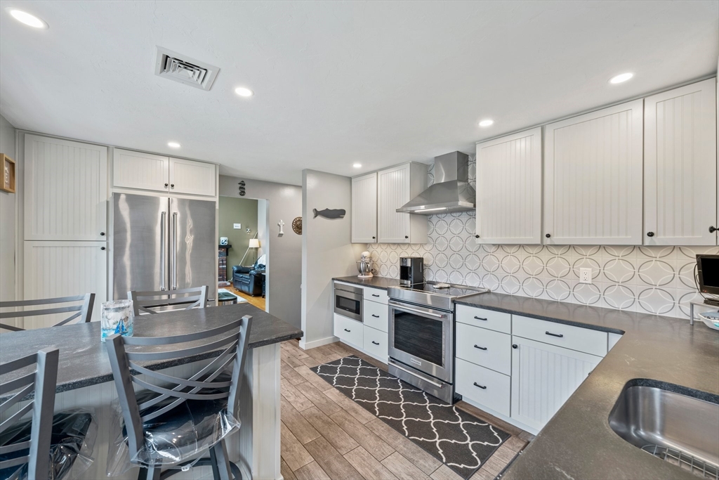 7 Signal Hill Road Marshfield, MA 02050 - Photo 4 of 42 a kitchen with refrigerator cabinets dining table and chairs