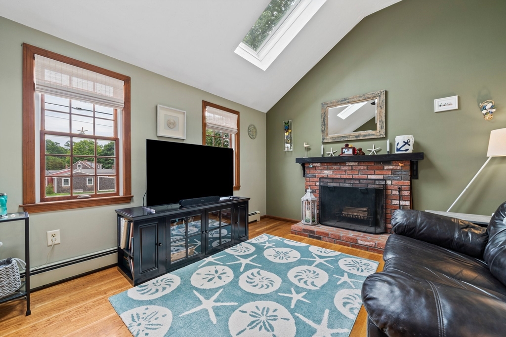 7 Signal Hill Road Marshfield, MA 02050 - Photo 10 of 42 a living room with furniture a flat screen tv and a fireplace