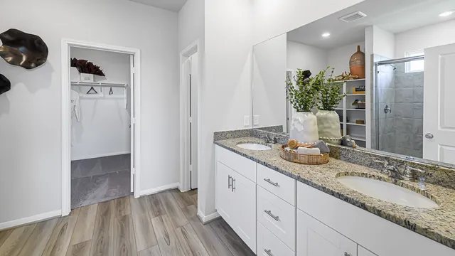 a bathroom with a granite countertop sink a mirror and shower