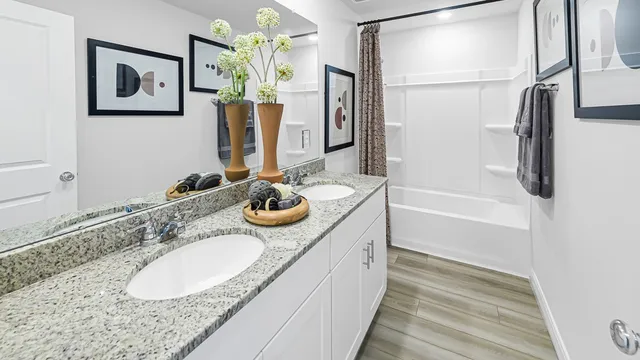 a bathroom with a granite countertop sink a mirror and a bathtub