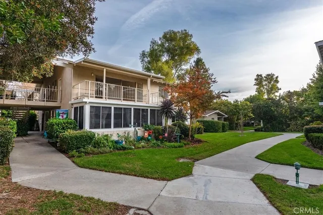 a front view of a house with a yard and potted plants