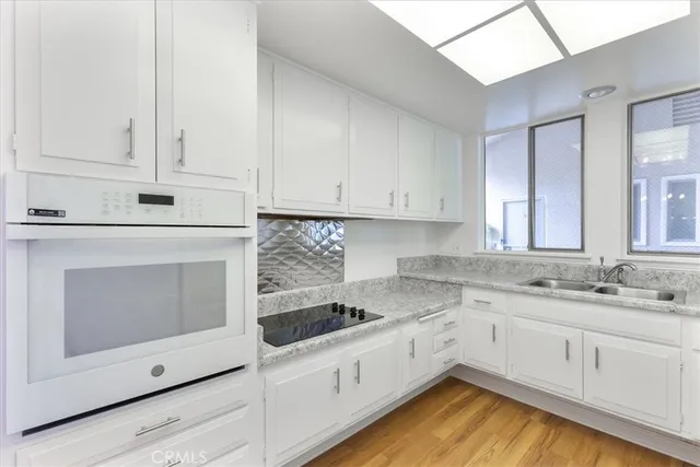 a kitchen with granite countertop white cabinets stainless steel appliances and sink