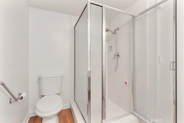 a white toilet sitting next to a shower