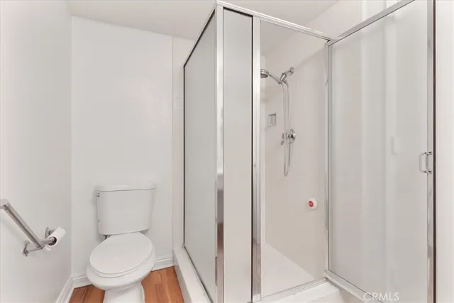 a white toilet sitting next to a shower
