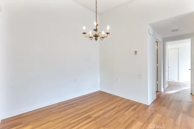 a view of a room with wooden floor and a ceiling fan