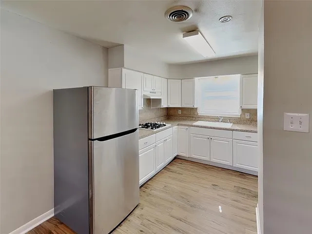 a kitchen with a refrigerator a sink and cabinets