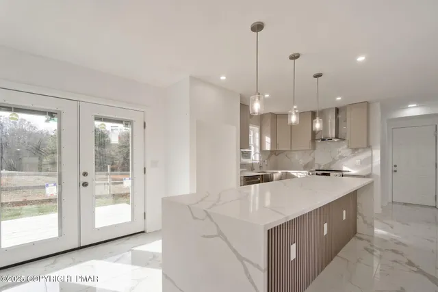 a large kitchen with kitchen island a large island a sink stainless steel appliances and cabinets