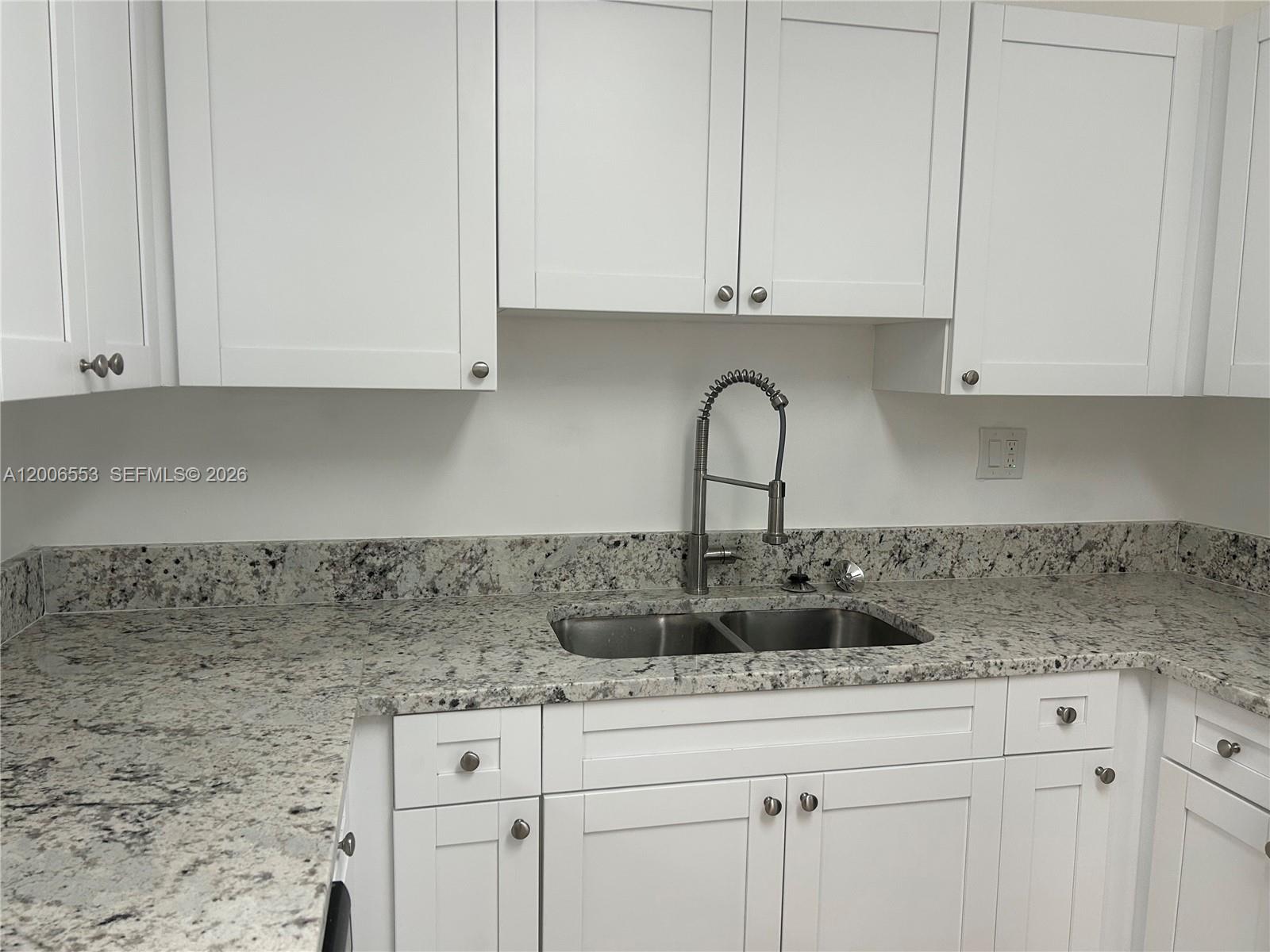 8445 Springtree Drive, Unit 202A Sunrise, FL 33351 - Photo 13 of 13 a kitchen with stainless steel appliances granite countertop white cabinets sink and granite counter tops