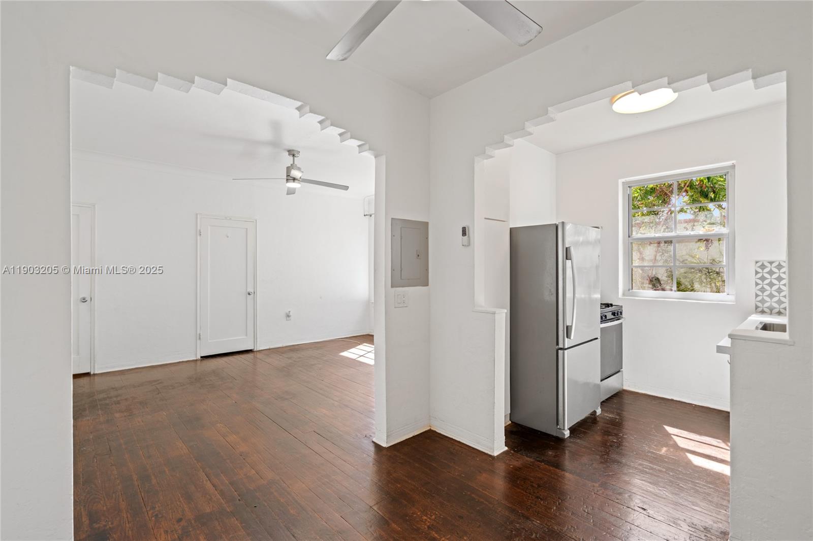 a view of a kitchen with wooden floor and a refrigerator