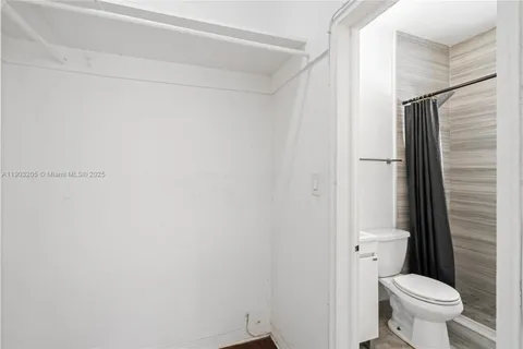 a bathroom with a toilet and a shower