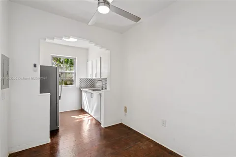 a view of a kitchen with a sink refrigerator and wooden floor
